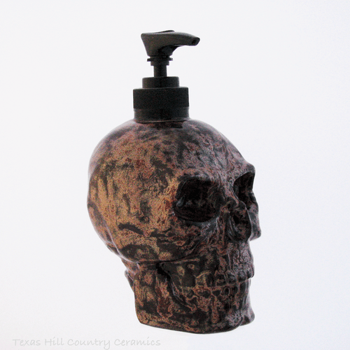 Skull soap dispenser with streaks of copper for bath vanity or kitchen counters.
