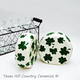 Round salt and pepper shakers with hand painted green shamrocks.  Made in the USA.