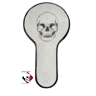 Black skull spoon rest with long handle for kitchen prep decor.