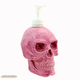 Bright pink skull soap dispenser with white pump unit.