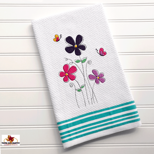 Spring flowers embroidered on white cotton towel.