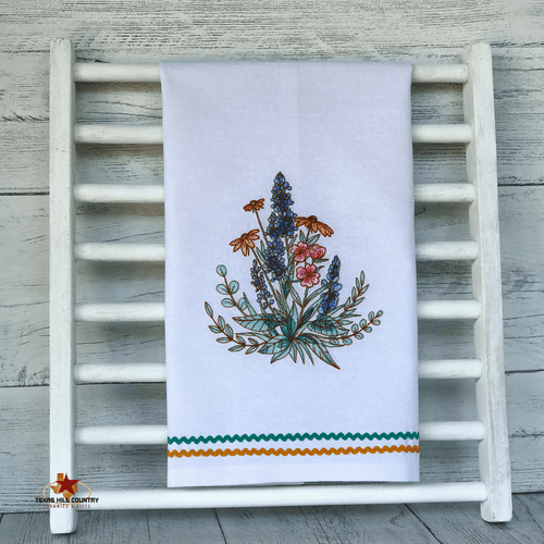 White cotton kitchen dish towel with Texas bluebonnet and wildflowers embroidery design.
