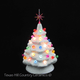 Small white ceramic Christmas tree with gum drop color lights and a red snowflake star