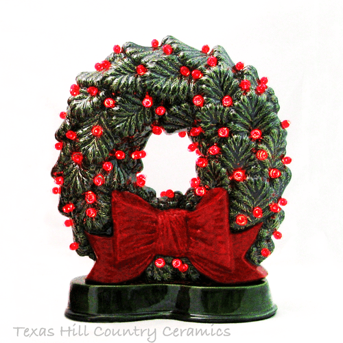 Small double sided lighted wreath with red bow and red berry like lights.