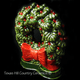 Ceramic lighted wreath with red bow and red lights for Christmas decorating on window sills or fireplace mantels.