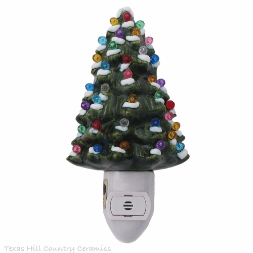 Green ceramic Christmas tree with snow tip branches and colorful globe lights.