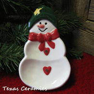 Snowman spoon rest with traditional red scarf, green hat, red heart buttons. Made in the USA by Texas Ceramics.
