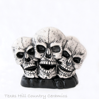 Three skulls in black antique on solid black rock base napkin holder or letter rack.