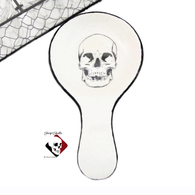 Ceramic spoon rest with skull design for haunted kitchens, paranormal accent.