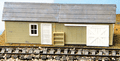 rectangular single story building with window, door and freight door.